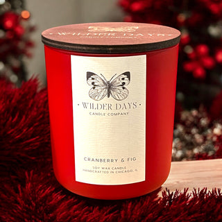 Hand-poured soy candle with X wood wick in a crimson vessel. Cranberry & Fig fragrance with notes of cranberry, mulled citrus, fig and cinnamon by Wilder Days Candle Company in Chicago.